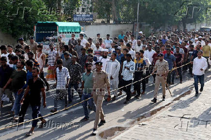 FILE PHOTO: Police officers escort men they believe to be undocumented Bangladeshi nationals after they were detained during raids in Ahmedabad