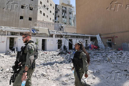 Members of the Israeli security forces walk near the Soroka Medical Center, after it was hit by a missile fired from Iran, in Beersheba