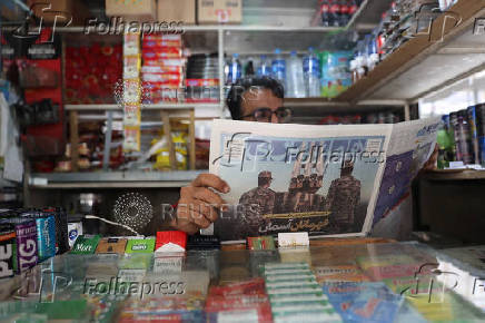 Man reads newspaper in Tehran