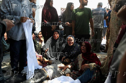 Palestinians gather around casualties of Israeli fire, who were seeking aid in northern Gaza, according to medics, in Gaza City