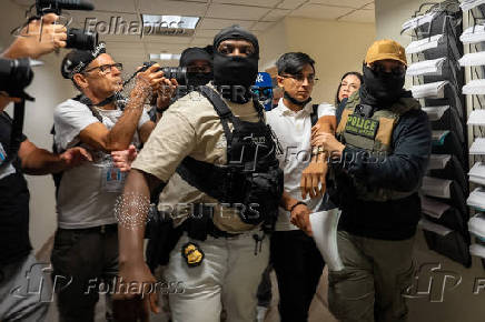 A migrant is detained by federal immigration officers at U.S. immigration court