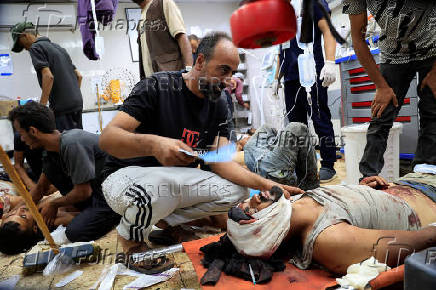 Palestinian casualties of Israeli fire, who were seeking aid, according to medics, are assisted at Nasser Hospital in Khan Younis, southern Gaza Strip