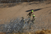 Members of the U.S. military replace concertina wire at on the U.S.-Mexico border, as seen from Ciudad Juarez