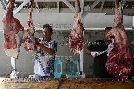 A volunteer prepares freshly slaughtered beef to be distributed for free to the public, during the sacrificial ritual celebrating Eid al-Adha, at a mosque in Banda Aceh