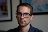 Ian Morgan, an employee at the National Institute for General Medical Sciences, sits for a portrait in Bethesda, Maryland