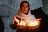 A Yazidi woman stands in front of a torch to mark Red Wednesday, the Yazidi New Year, at the Lalish temple in Shekhan district near Dohuk provinc