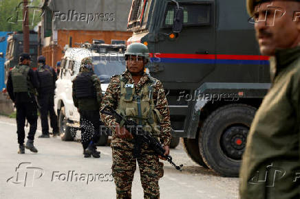 Indian security force personnel stand guard near the site of a fighter jet crash in Wuyan