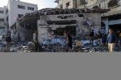 Palestinians inspect destroyed building after Israeli airstrike in Gaza City