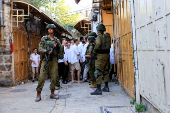 Israeli troops stand guard during a weekly settlers' tour in Hebron