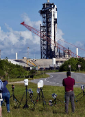 Photographers set up remote cameras as a Falcon 9 rocket stands at Launch Complex 39-A while the Axiom-4 crewed mission prepares for its launch to the International Space Station