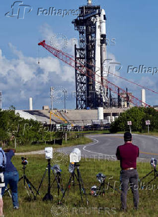 Photographers set up remote cameras as a Falcon 9 rocket stands at Launch Complex 39-A while the Axiom-4 crewed mission prepares for its launch to the International Space Station