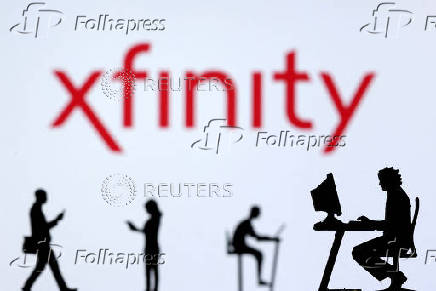 FILE PHOTO: Illustration shows small toy figures with laptops and smartphones in front of displayed Xfinity Internet logo