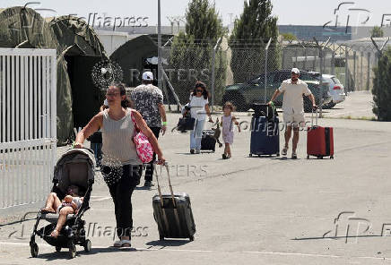 French nationals evacuated from Israel to Cyprus walk outside the Joint Rescue Coordination Center 