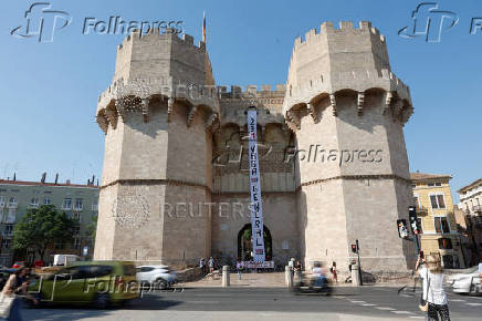 Protesters hang a giant banner that reads