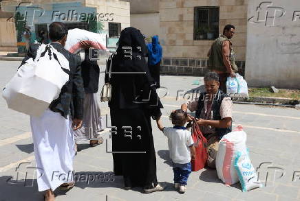 Yemenis receive food aid in Sana'a, distributed by Mona Relief agency