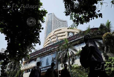 FILE PHOTO: Men walk past a screen displaying market results outside the Bombay Stock Exchange (BSE) in Mumbai