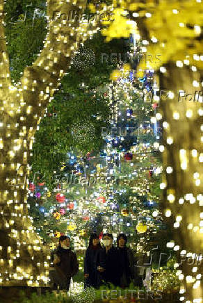 People walk under lights celebrating the upcoming the Christmas season at a park in Tokyo