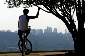 Ciclista observa a vista do alto da Praça do por do Sol