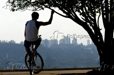 Ciclista observa a vista do alto da Praça do por do Sol