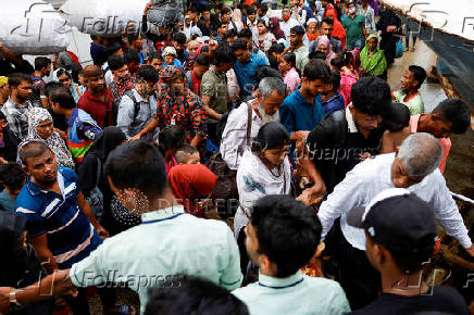 People board passenger ferries as they leave to celebrate Eid al-Adha with their families, in Dhaka