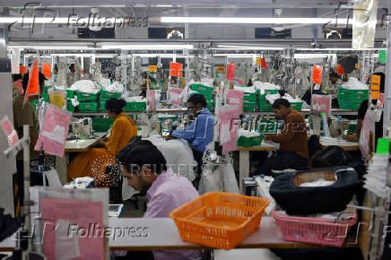 Workers sew garments inside a garment factory in Faridabad