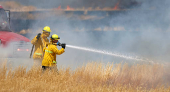 Firefighters battle flames during brushfire in Woodland California