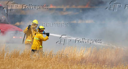 Firefighters battle flames during brushfire in Woodland California