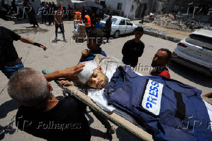 Mourners carry the body of a Palestinian journalist Ismail Baddah, who was killed in an Israeli airstrike on Al-Ahli Arab Hospital, in Gaza City