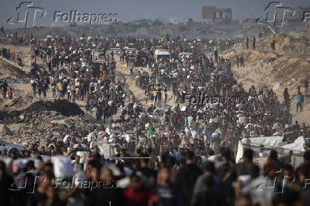Displaced Palestinians carry relief parcels along Rashid Street, west of Gaza City
