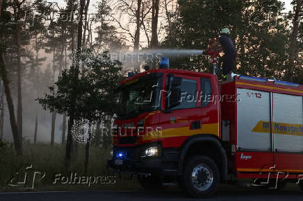 Firefighters work to extinguish a wildfire in Gohrischheide