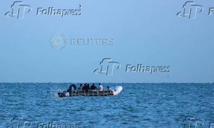 A group of migrants sit on a dinghy whilst trying to cross the English Channel near Gravelines