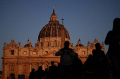 People walk in front of St. Peter's Basilica in St. Peter's Square ahead of the conclave, which will be held on May 7, at the Vatican
