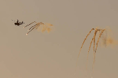An Israeli Apache helicopter releases flares as it flies over northern Gaza