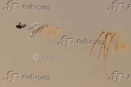 An Israeli Apache helicopter releases flares as it flies over northern Gaza