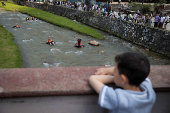 Sports enthusiasts compete while floating on inner tyre tubes during the tyre festival 'Bunar Fest' in Prizren