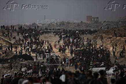 Displaced Palestinians carry relief parcels along Rashid Street, west of Gaza City