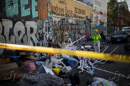 FILE PHOTO: A worker stands on a corner during a street cleaning operation in Skid Row Los Angeles