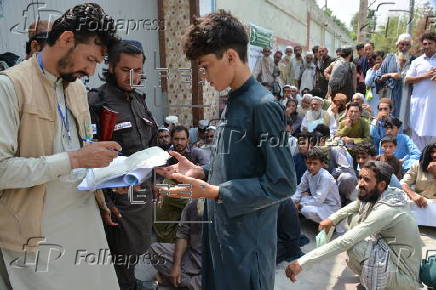Afghan families, returned from neighboring Pakistan, receive food rations distributed by the Tawheed Charity Foundation in Jalalabad