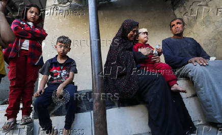 Palestinians inspect the damage at the site of an Israeli strike on a house, in Jabalia