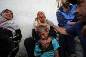 Mourners react during the funeral of Palestinians killed in overnight Israeli strikes, according to medics, at Al-Shifa hospital in Gaza City