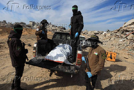 Palestinian Hamas and Islamic Jihad militants recover a body at a site as Hamas says it continues to search for the bodies of deceased hostages, in Beit Lahiya