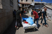 People carry the body of a Palestinian, killed in an Israeli airstrike on Al-Ahli Arab Hospital, in Gaza City