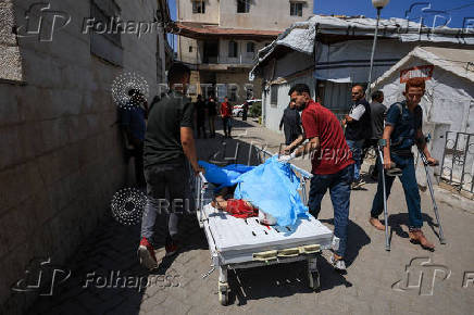 People carry the body of a Palestinian, killed in an Israeli airstrike on Al-Ahli Arab Hospital, in Gaza City