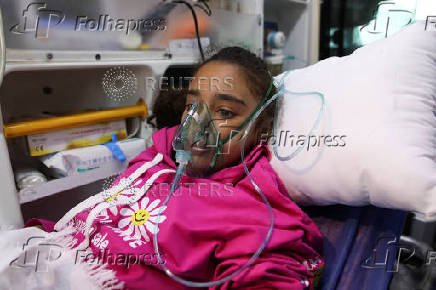 A Palestinian girl breathes through an oxygen mask inside an ambulance in Amman
