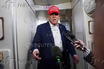 U.S. President Donald Trump speaks to members of the media on board Air Force One on the way to New Jersey