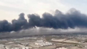 An aerial view shows plumes of thick black smoke rising, following a suspected explosion of chemical materials