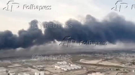 An aerial view shows plumes of thick black smoke rising, following a suspected explosion of chemical materials