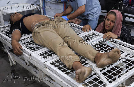 A Palestinian wounded in an Israeli strike is assisted, at Al-Ahli Arab Baptist hospital, in Gaza City