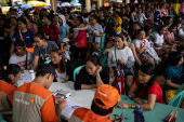 Residents affected by monsoon rains queue for relief following monsoon rains in Quezon City