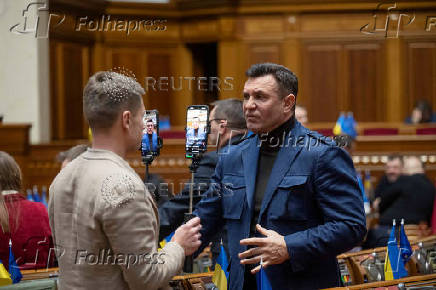 Lawmaker Oleksii Honcharenko holds smartphones as he live streams a session of Ukrainian parliament in Kyiv